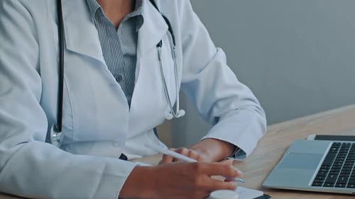 Terapeuta, médica general, mujer africana, doctora con máscara, sentada en la clínica del hospital