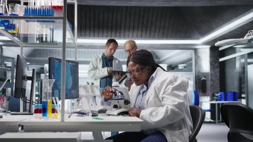 African American Scientist Placing Tray Under the Microscope