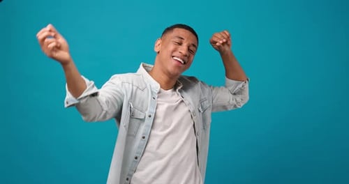 Happy Young African American Man Dancing Over Blue Studio Background