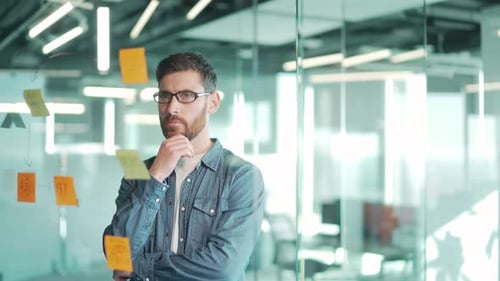 Man Brainstorming with Sticky Notes in Modern Office