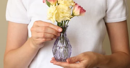 Woman Holding Flowers in Vase Close Up Shot