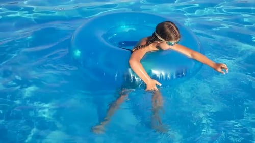 Little Girl Jumps Into an Inflatable Circle with a Pool Side Children Have Fun and Play Dives on the