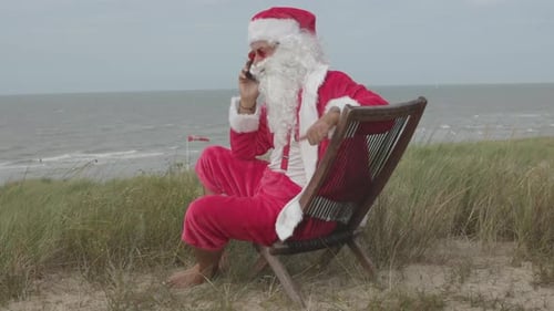 Santa Claus Talks on Phone at the Beach