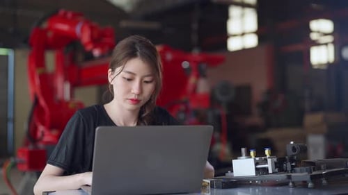 Female engineer in a black shirt works intently on her laptop
