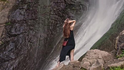 Woman With Long Hair Standing Near Waterfall