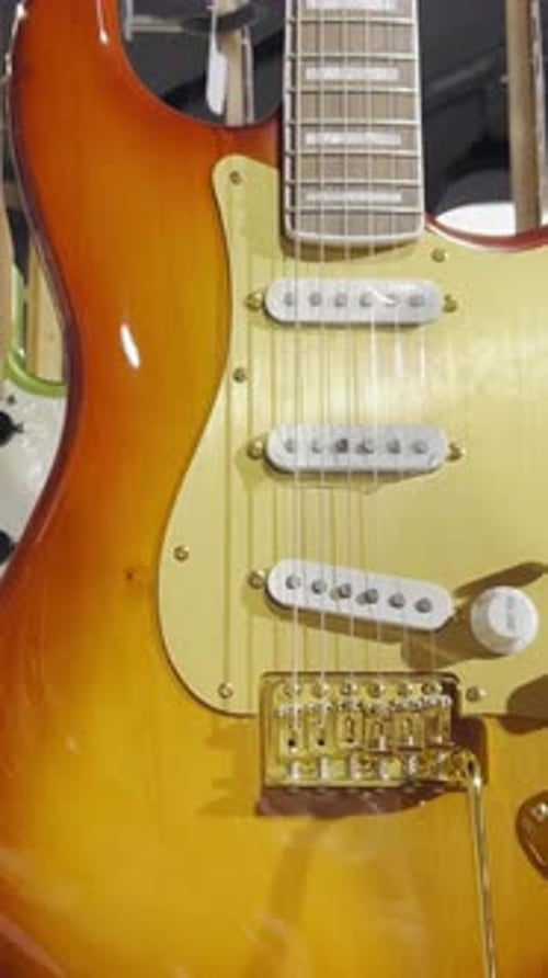 Closeup of Colorful Electronic Guitars Hanging on the Wall of a Shop A Collection of Bass Guitars