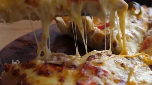 Cheesy Pizza Slice Being Lifted with Melted Cheese