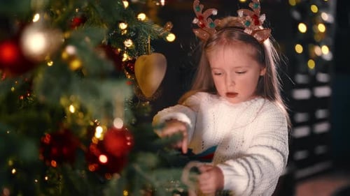 Girl Decorating Christmas Tree at Home