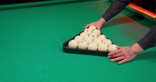 Man Arranges Billiard Balls on Pool Table