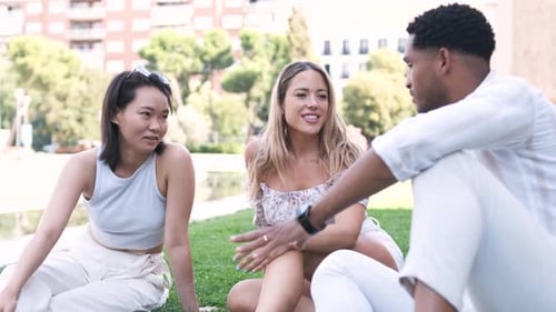 Multiethnic Friends Talking While Sitting at City Park During Daytime