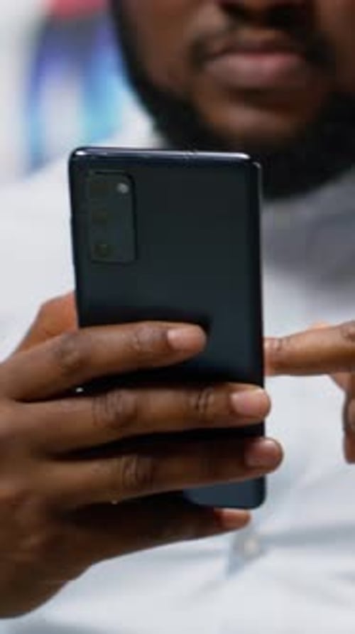 Vertical Video African American Adult Browsing His Smartphone That Walks Along Avenue