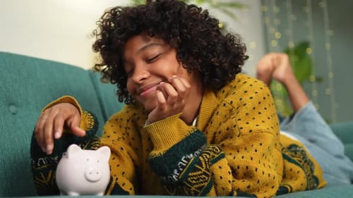 Saving Money Investment for Future African American Girl Putting Money Coin in Pink Piggy Bank