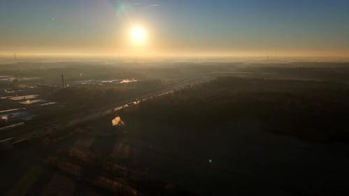 Aerial establishing shot of traffic scene on american highway during foggy sunrise. Wide shot. Golde
