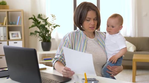 Working mother balances baby boy and business at home office
