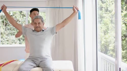 Senior Man Stretching with Resistance Band at Home