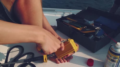 Men fix the boat. Two young men fix broken device on the sailboat