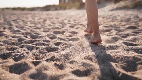 Back View of Tanned Woman Legs and Feet Walking on Sandy Beach to the Sea on Sunny Day Slim Pretty