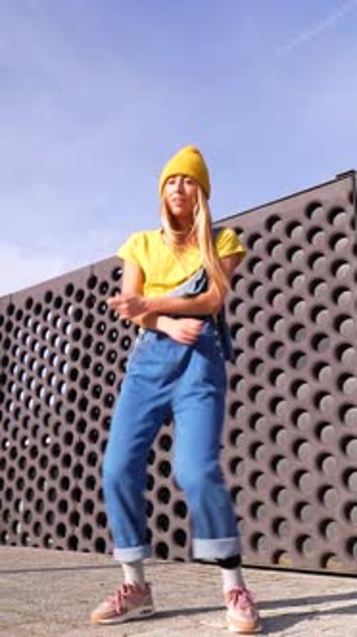 Young Woman Dancing Energetically in Urban Setting