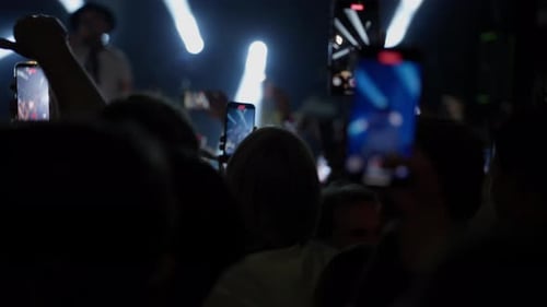 Energetic Crowd Records Performing Musician at Night
