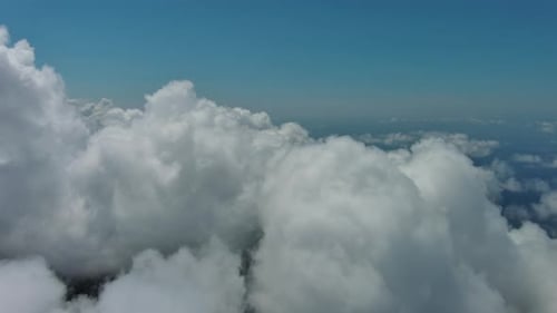 Flying through white clouds over sea