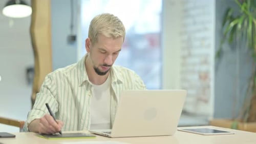 Graphic Designer Drawing on Laptop with Graphic Tablet