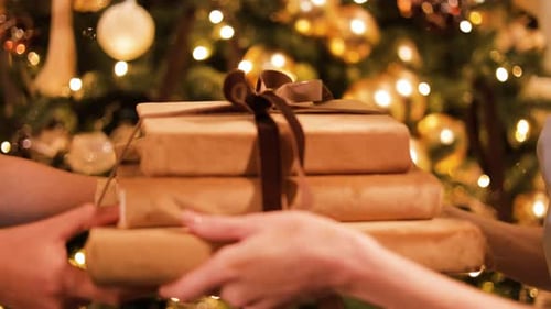 Exchanging Christmas Gifts in Front of Tree