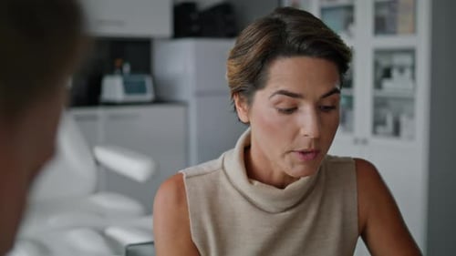 Woman Examined Medical Card Checking Information in Cosmetology Clinic Close Up
