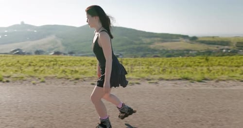 Woman Roller Skating on Rural Road in Sunlight