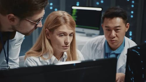 Team Collaborating on Computer Code in Futuristic Workplace