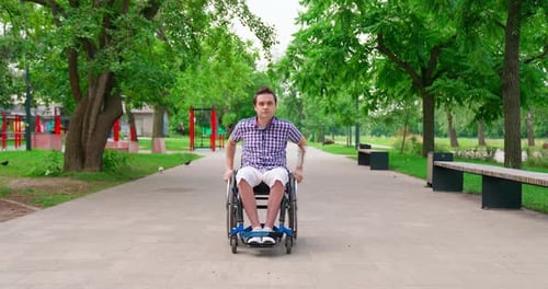 Man in Wheelchair on Path in Park