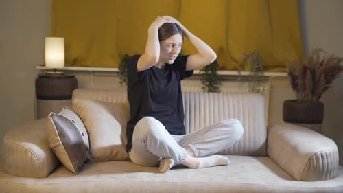 Desperate young woman with her hands on her head. Depressed.