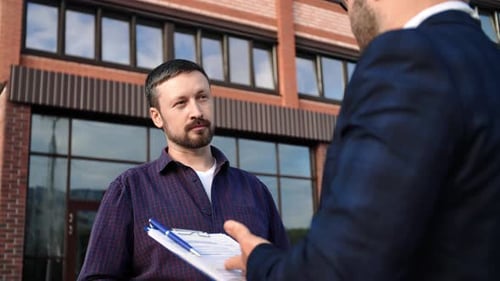 Men Discuss Business in Front of Building