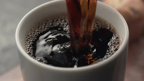 Dark Coffee Pouring into White Mug Close Up