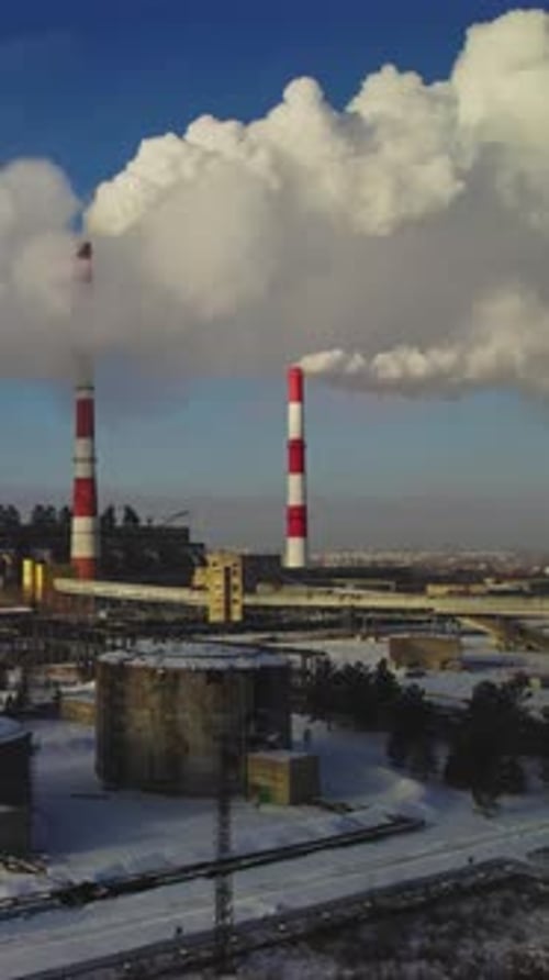 Aerial view of industrial plant smokestacks in winter