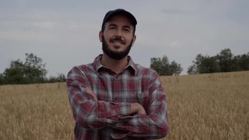 Farmer in Wheat Field Smiling With Arms Crossed