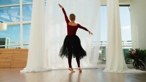 Ballet dancer in tutu practices in sunny studio