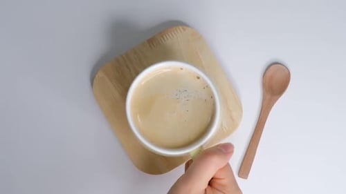 Weibliche Hände nehmen eine Tasse Kaffee Frau wärmt sich die Hände mit einer heißen Kaffeetasse Zoom-Out-Aufnahme Nahaufnahme