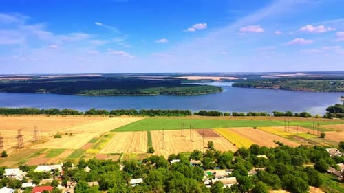 Stunning view of the wheat fields, river and forests on sunny summer day.