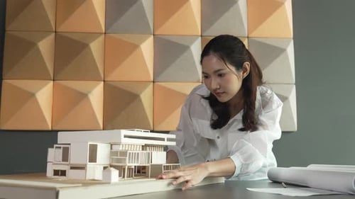 Architecte asiatique professionnel regardant un modèle de maison. Manipulateur.