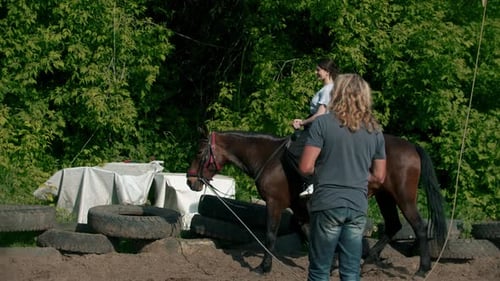 Woman Learning Horseback Riding in a Paddock