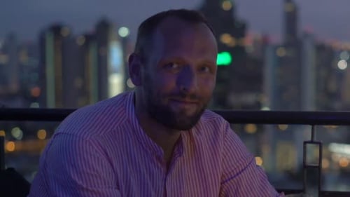 Man Drinks Wine with City View at Night