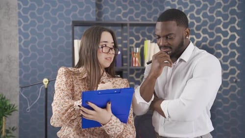 Joyeux et joyeux collègues multiethniques discutant à travers des notes et des projets.