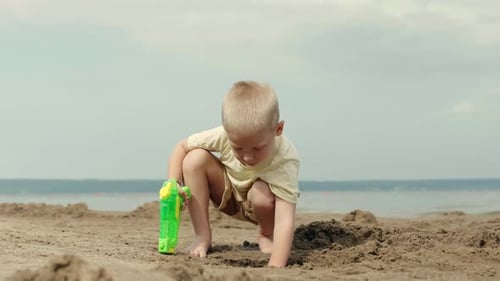 Boy Digging Sand on Beach