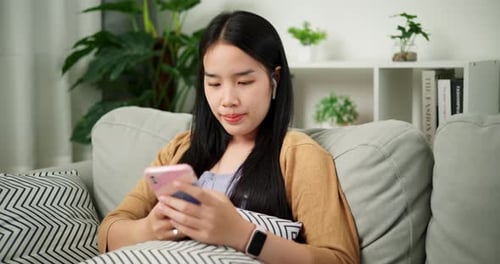 Young Woman Using Smart Phone on Couch