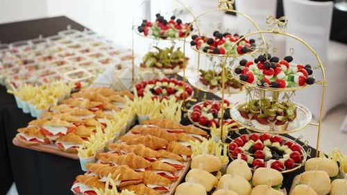 Catering buffet table with a variety of sandwiches, sliders, and appetizers.