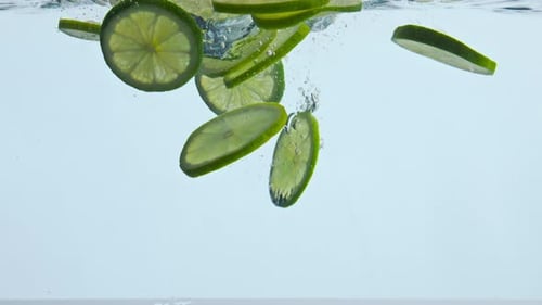 Lime Slices Falling into Water, Refreshing and Clean