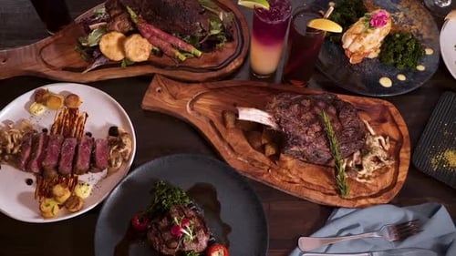 Top down view tabletop full of elegantly plated dinner options at an expensive romantic steakhouse,