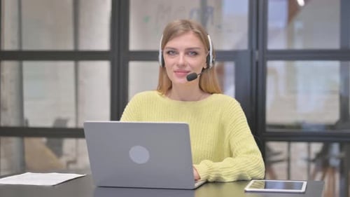 Blonde Woman with Headset in Call Center Smiling at Camera