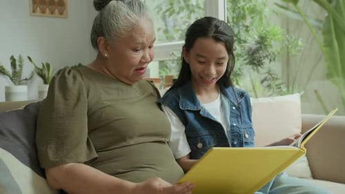 Grandmother and Granddaughter Reading Together at Home