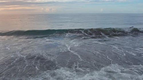 Cinematic Slow Motion of Ocean Waves Rolling on Shore at Sunset